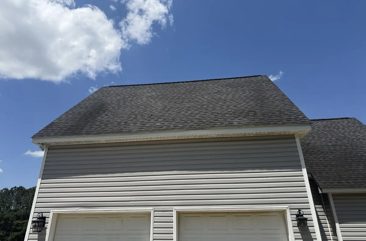 The original weathered shingle roof with dark streaking over the attached garage of a Benson, North Carolina home, before replacement