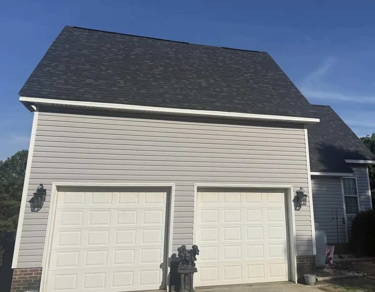 New Owens Corning Oakridge shingle roof in Onyx Black over the attached garage of a Benson, North Carolina home, after replacement