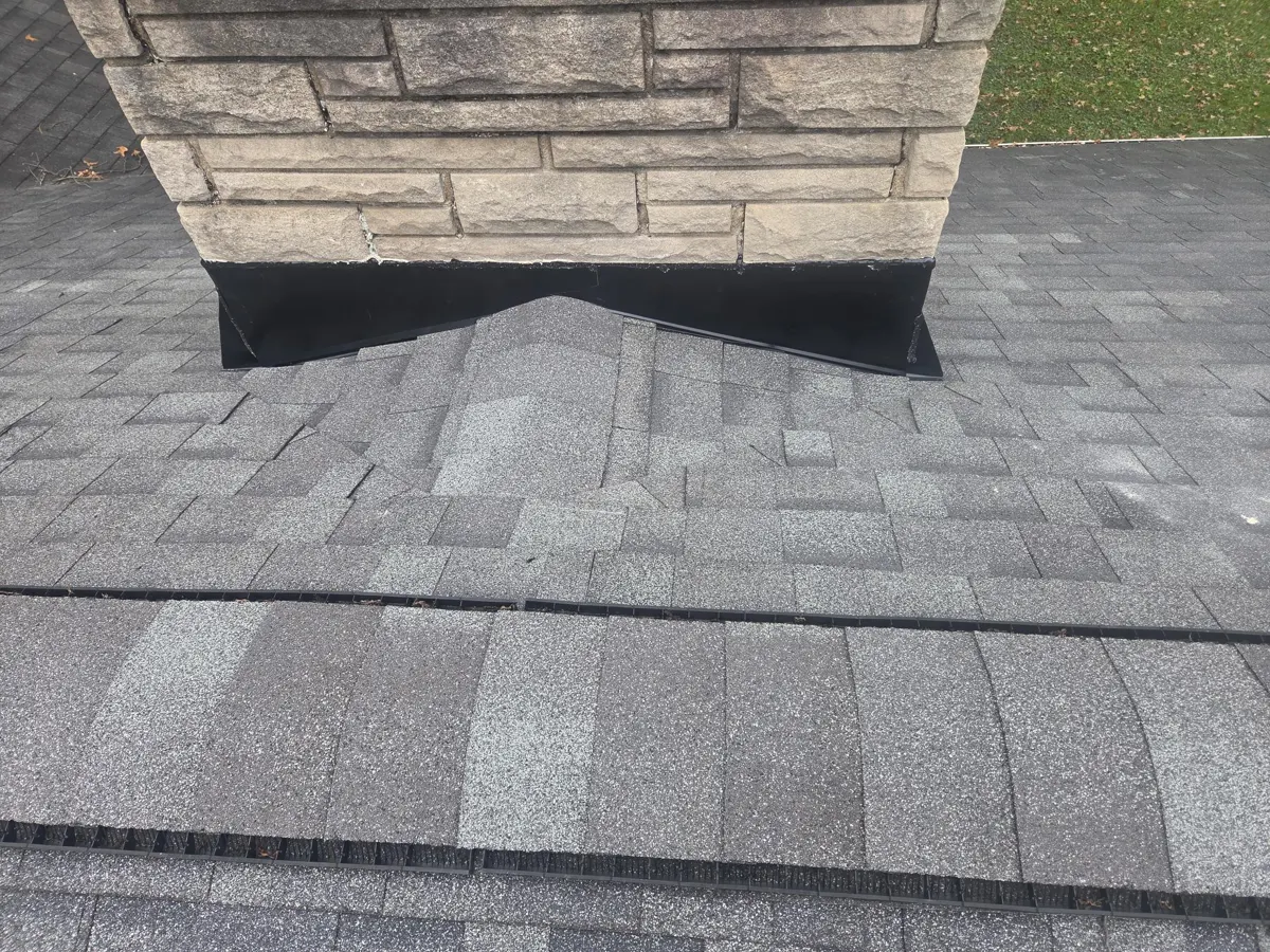 New cricket shingled in behind the chimney with new black flashing in Blacklick, Ohio, after repair