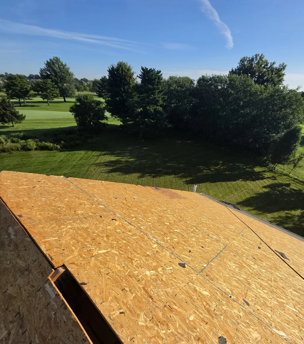 Old shingles torn off down to the OSB roof deck, with the ridge vent opening cut, during a roof replacement in Delaware, Ohio