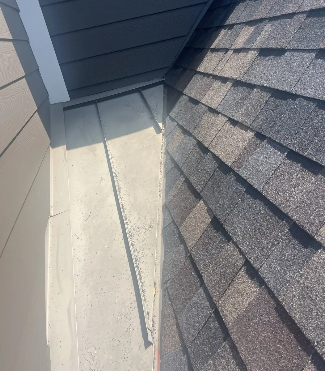New shingles meeting the metal roof section beside the siding on a Delaware, Ohio home, after roof replacement