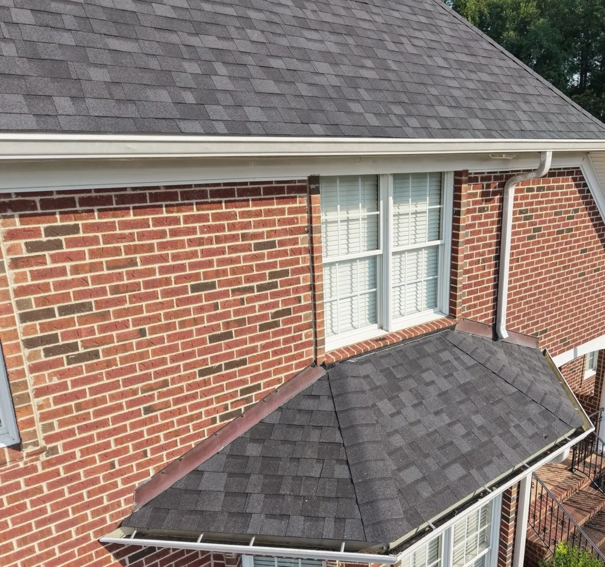 Old shingles on a lower roof section of a brick home in Dunn, North Carolina, before replacement