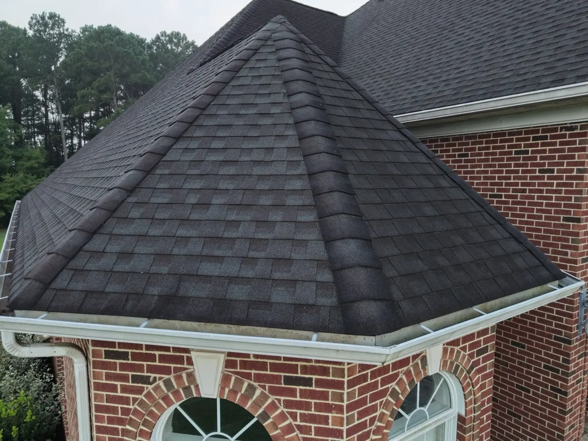 New dark architectural shingles on a hip roof section in Dunn, North Carolina, after replacement
