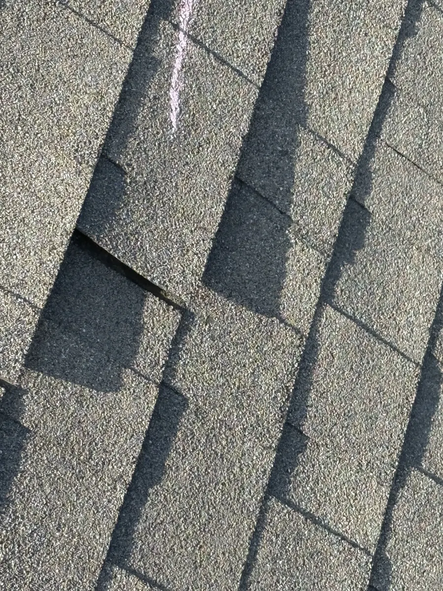 A creased shingle tab marked in chalk during the storm inspection in Dunn, North Carolina, before replacement