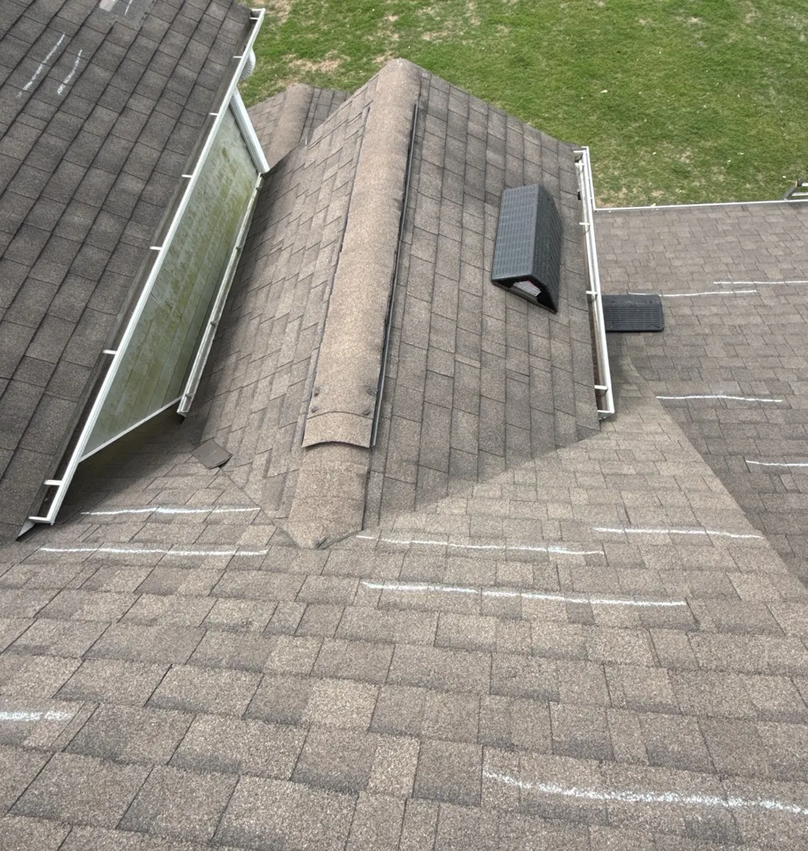 Chalk-marked shingles around a dormer next to a skylight in Dunn, North Carolina, before replacement