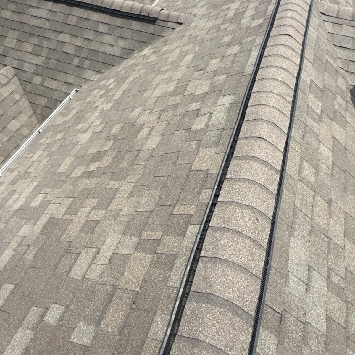 New ridge vent and hip and ridge caps along the main ridge of a Dunn, North Carolina home, after replacement