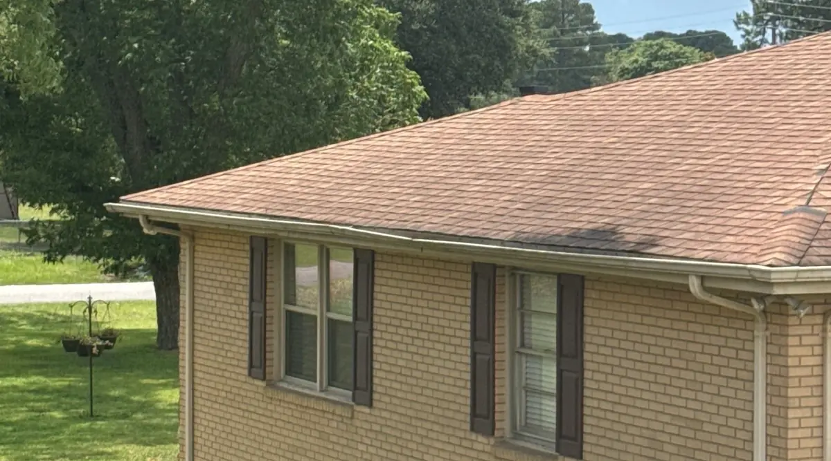 The original weathered shingle roof over a brick wall on a Goldsboro, North Carolina home, before replacement
