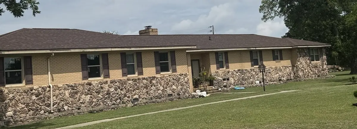 New brown Owens Corning Oakridge shingle roof on a single-story brick home in Goldsboro, North Carolina, after replacement