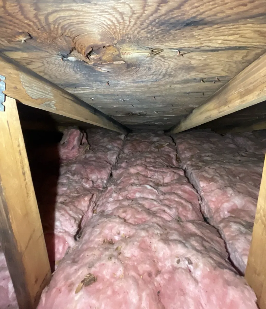 Water-stained roof decking seen from the attic above the leak in Groveport, Ohio, before repair
