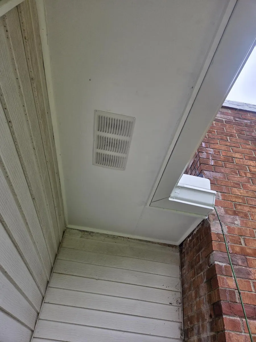 New soffit with a soffit vent and new fascia and gutter at the chimney corner in Groveport, Ohio, after repair