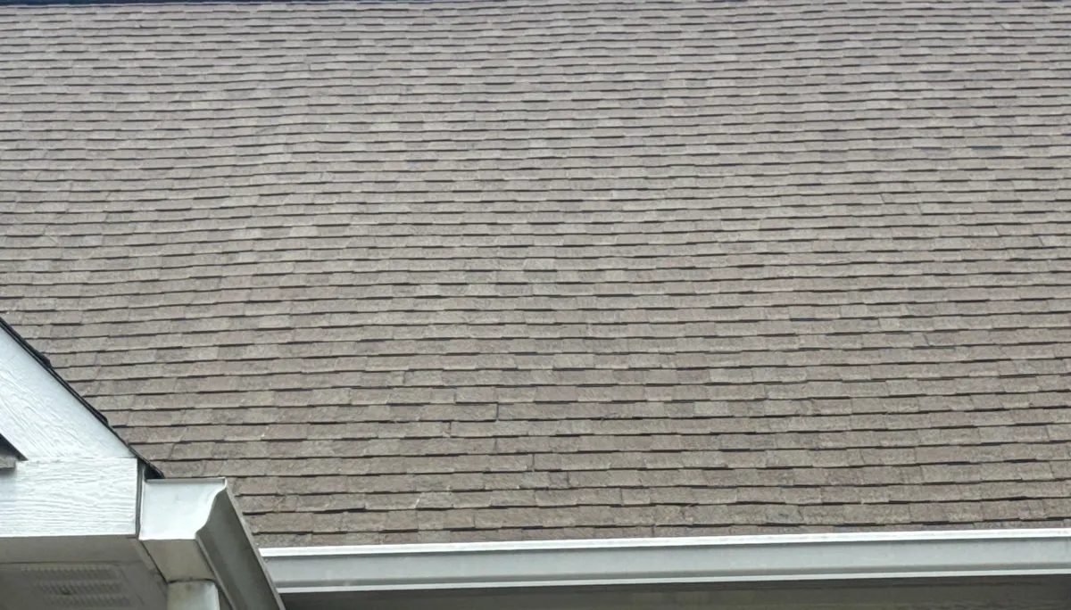 Aged shingles above the gutter line on a Linden, North Carolina home, before replacement