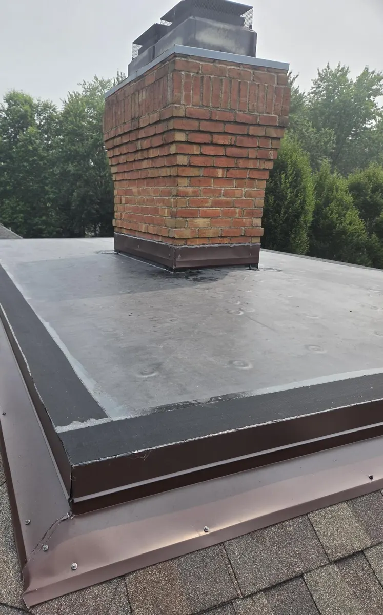 New black EPDM rubber membrane with brown drip edge and apron flashing on the flat roof in New Albany, Ohio, after repair