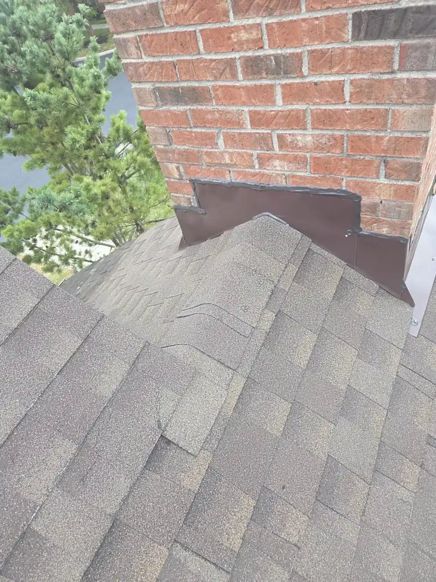 New chimney flashing and shingles around a brick chimney in Powell, Ohio, after repair