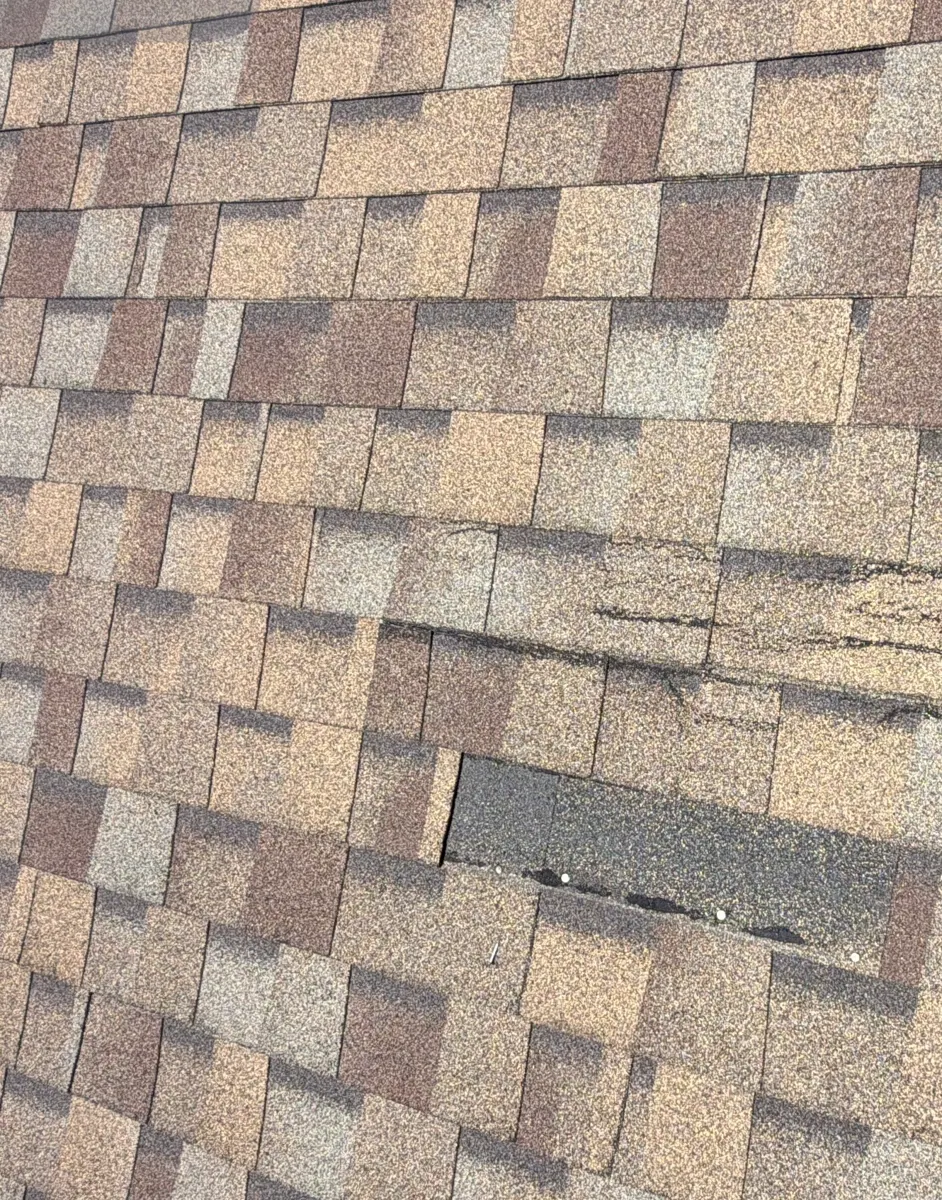 Missing shingle tab and creased shingles on a Reynoldsburg, Ohio roof at the storm inspection