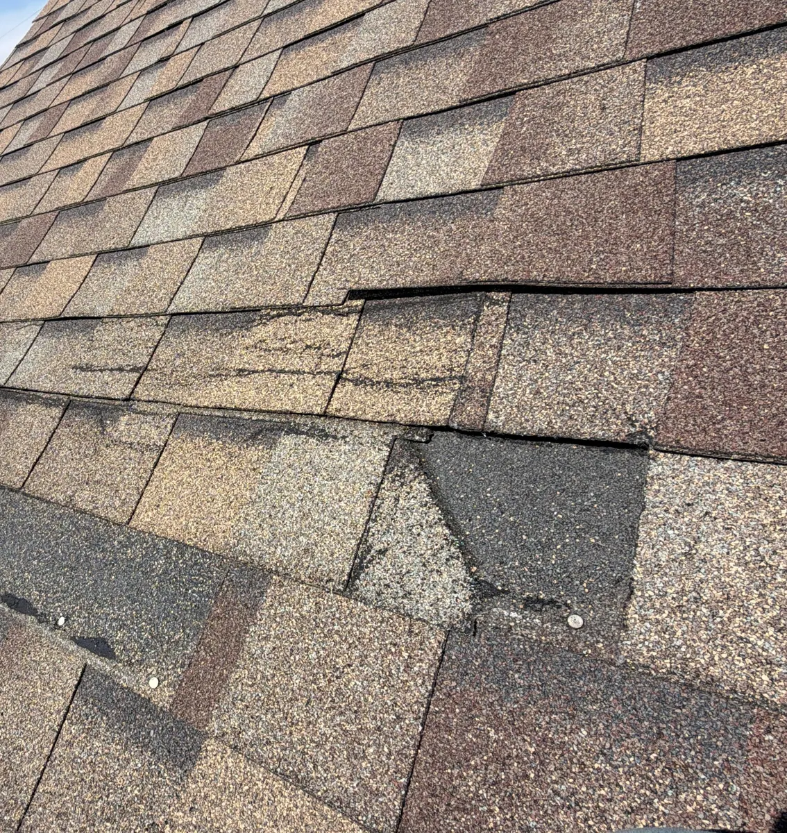 Creased and missing shingle tabs along one course on a Reynoldsburg, Ohio roof, before repair
