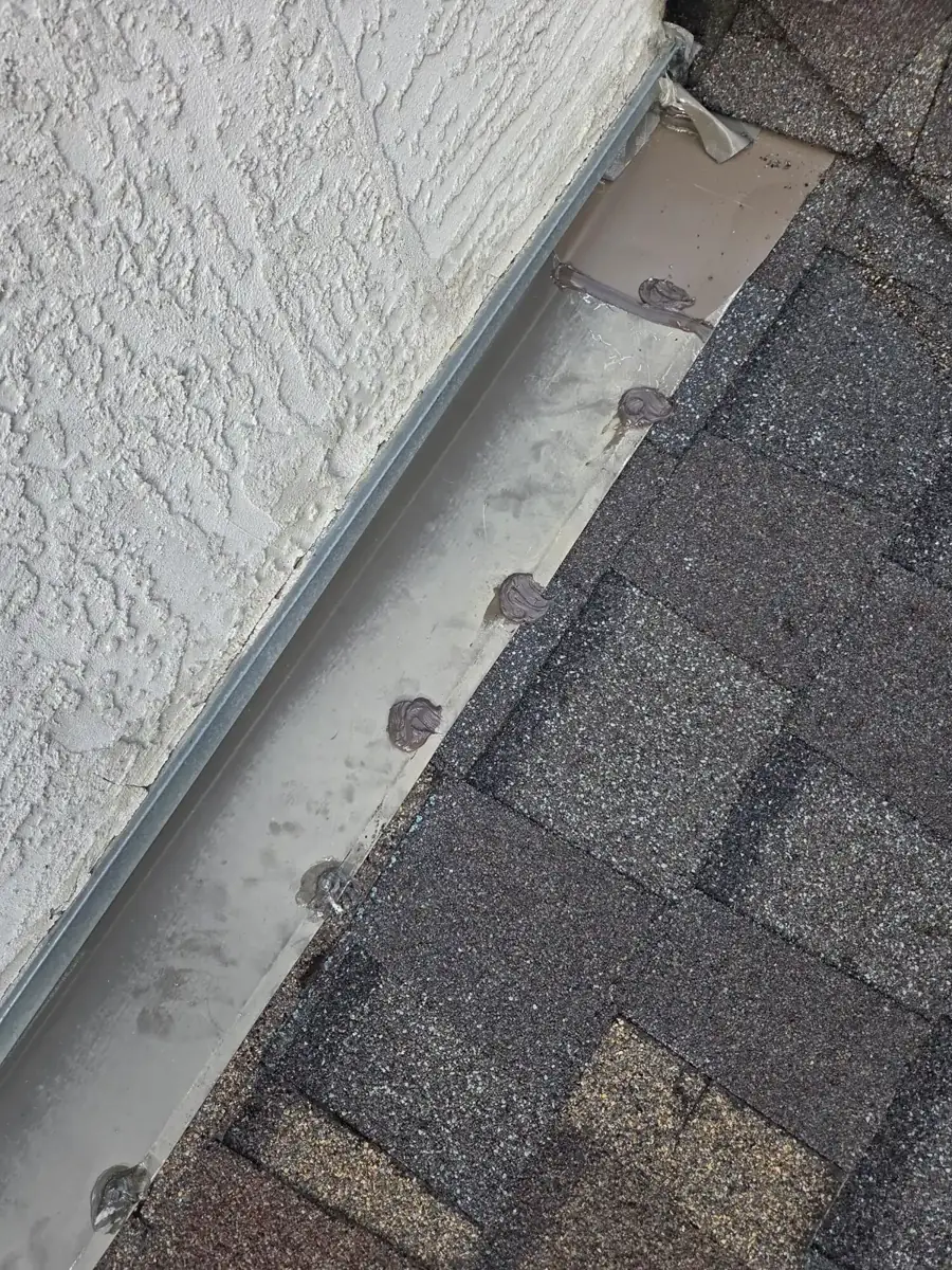 New sidewall flashing and shingles along the wall above the gutter in Westerville, Ohio, after repair